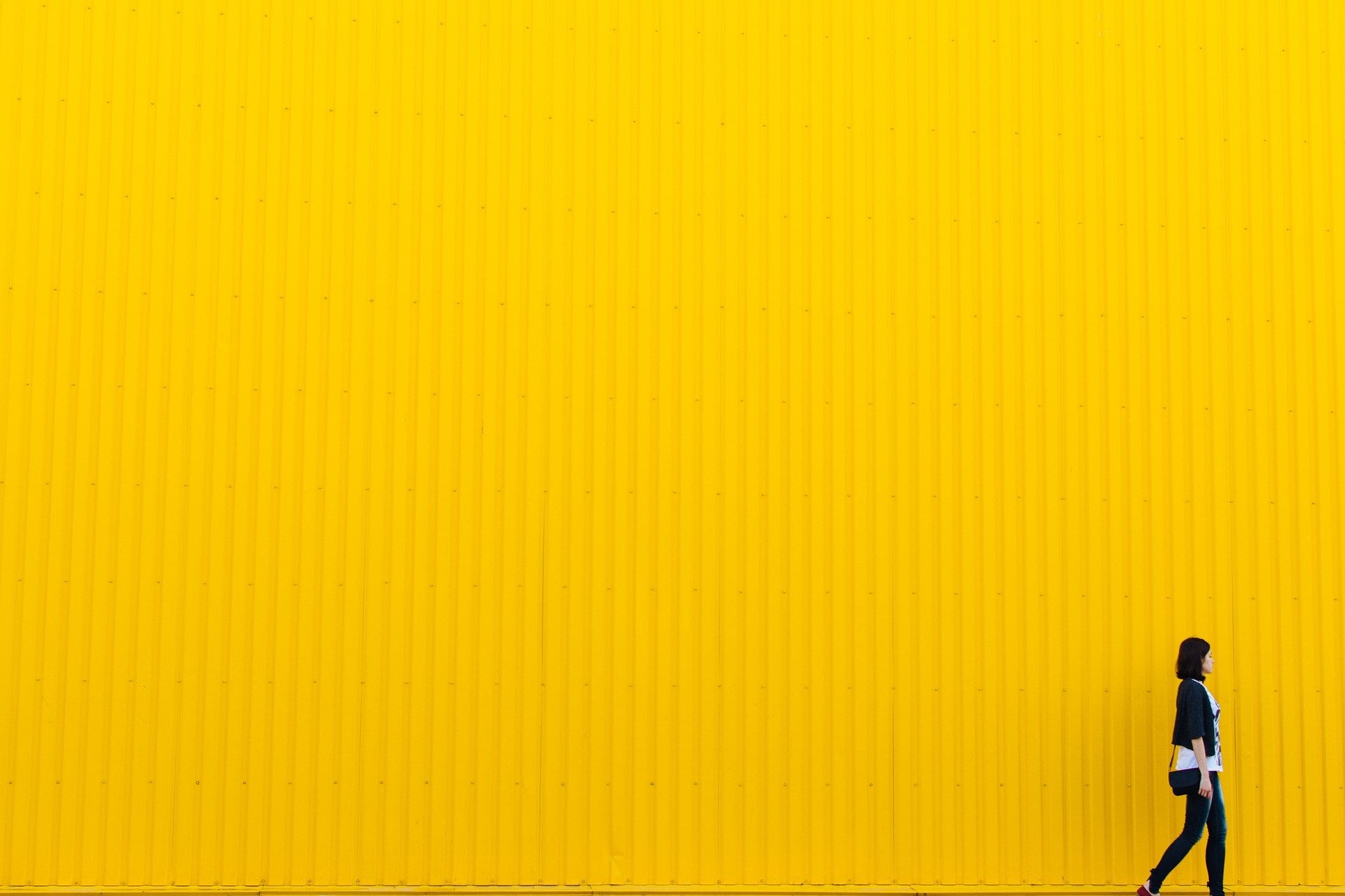 Persona caminando sobre una pared amarilla